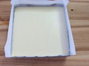 把蛋糕糊倒入垫好油纸的模具，震模具几下，把蛋糕糊表面的大气泡震出去