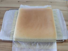 提油纸四周把古早味蛋糕取出，放凉网上，趁热把油纸撕掉