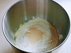 再加入奶粉，高筋面粉，最后加入酵母粉，再用旁边的面粉将酵母粉盖起来，启动厨师机2档揉面10分钟。