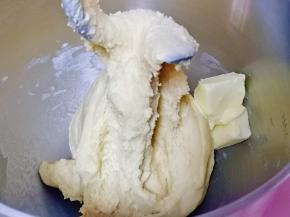 10分钟后面团处于扩展阶段，加入室温软化的黄油，继续启动厨师机3档揉面，揉出不容易破的手套膜即可。