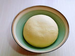 将面团取出揉圆，放入器具中，盖上保鲜膜进行发酵。(注意保持面团的湿度)