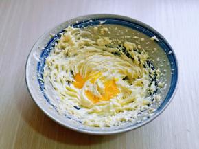 待黄油蓬松的状态时加入一半的蛋液，电动打蛋器低速打至均匀。