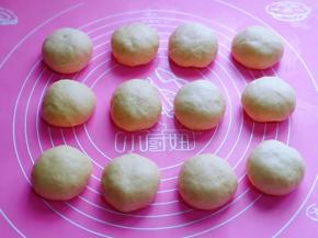 这时面包的面团也发酵好了，用手指摁一下，不回缩，不反弹即为发酵完成，揉圆排气后，将面团分成12等份。