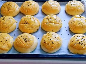 发酵好的菠萝包胚明显变大，刷上一层蛋液，再撒上黑芝麻。
