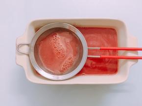 将混合好的西瓜果冻液过滤掉泡沫，倒入模具中