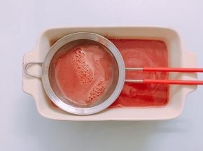 将混合好的西瓜果冻液过滤掉泡沫，倒入模具中