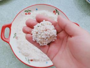 再依次放入控干水分的糯米中滚一圈，使其表面全部沾满糯米