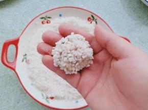 再依次放入控干水分的糯米中滚一圈，使其表面全部沾满糯米