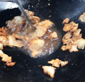 腊肉焯水后放入锅中，煎至金黄色