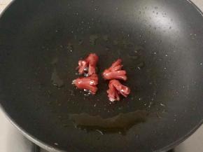 把小香肠也放入锅中，煎制片刻，切开的部分受热会张开。