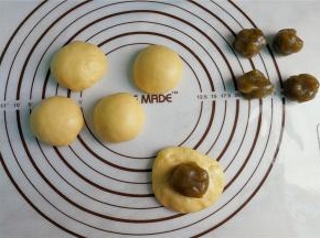 把每个面团揉搓排气，利用掌腹把面团按扁包入抹茶莲蓉馅，封口揉圆。