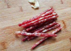 首先把小腊肠切丁，蒜瓣去皮切片备用。