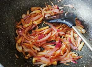 炒制变软后，倒入盐和生抽调味，继续翻炒洋葱丝。