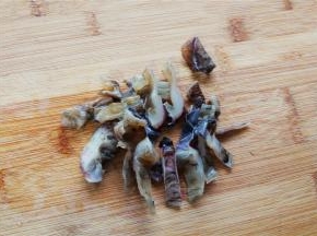 把墨鱼干冷水泡发好，洗净切成小段。