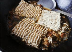 锅中沸腾后，把面饼放入煮软，让波纹面吸收汤汁变即可出锅。