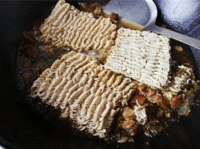 锅中沸腾后，把面饼放入煮软，让波纹面吸收汤汁变即可出锅。