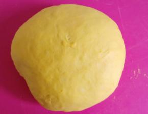 面团发酵好后取出排气。排好气后盖保鲜膜松弛十分钟。