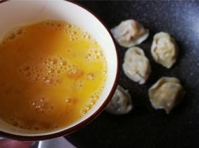 鸡蛋磕入碗中打散撒入少许盐，饺子摆放好，慢慢浇入蛋液。