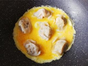 开中火让蛋液慢慢凝固起来，包裹住饺子。