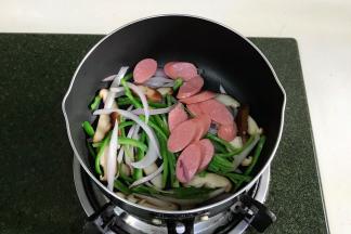 接着加入香肠片翻炒片刻。