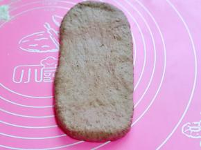 取一块面团，擀长舌状，从上而下卷起。