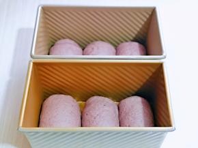 再次用擀面杖擀长舌状，由上至下卷起，依次做完，放入模具中进行二发。