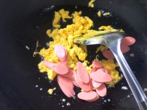 倒入火腿肠翻炒至变色