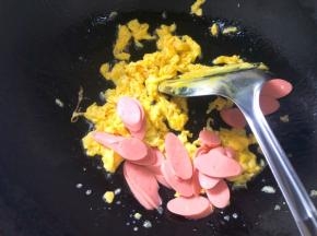 倒入火腿肠翻炒至变色