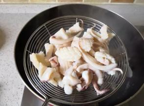 锅里倒人适量的清水，加入料酒

水沸腾后倒入鱿鱼焯一下水

时间不要长

变色后立马捞出