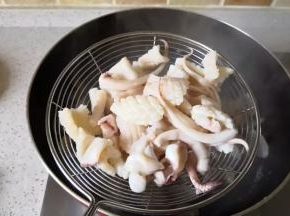 锅里倒人适量的清水，加入料酒

水沸腾后倒入鱿鱼焯一下水

时间不要长

变色后立马捞出