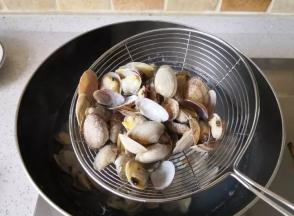 接着倒入花蛤，煮到花蛤壳都张开后捞出