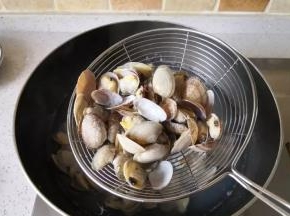 接着倒入花蛤，煮到花蛤壳都张开后捞出