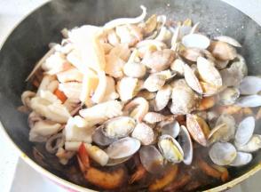 加入鱿鱼和花蛤翻炒均匀