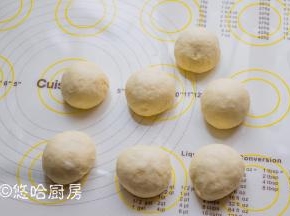 面团移至案板上，平均分成7份（也可以分成6份或5份），滚圆后醒发15分钟。
