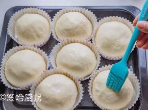 发酵到位的面团在表面刷一点牛奶，刷蛋液也可以，撒一点白芝麻（没有可省略）。