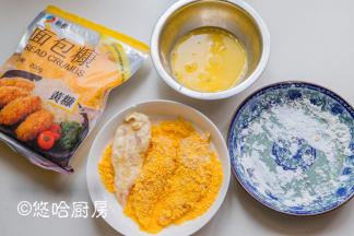 面包放凉后，开始做汉堡。把腌渍后的鸡胸肉先放入淀粉中沾满2面，再去沾满蛋液，最后在面包糠中打个滚。