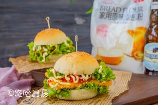 汉堡包从中间切开，先铺上一层生菜、西红柿片（蔬菜要提前洗净控水），放一块煎熟的鸡胸肉，再放一层生菜，挤上沙拉酱或番茄沙司，就可以开吃了。