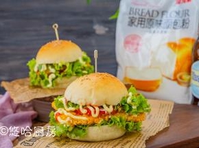 汉堡包从中间切开，先铺上一层生菜、西红柿片（蔬菜要提前洗净控水），放一块煎熟的鸡胸肉，再放一层生菜，挤上沙拉酱或番茄沙司，就可以开吃了。