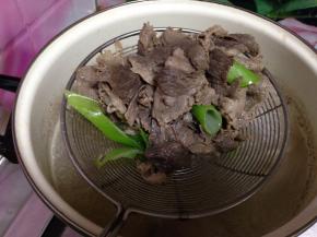 锅内加水、葱段烧开，倒入肥牛片烫10秒捞出控水