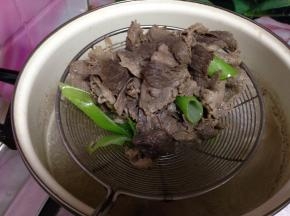 锅内加水、葱段烧开，倒入肥牛片烫10秒捞出控水