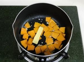 开火，锅中倒入食用油，加入蒜蓉爆香，接着加南瓜翻炒，加黄油。