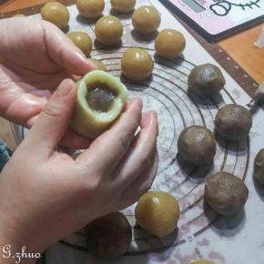 取出静置好的月饼皮，每个23克，用包包子的手法，把面皮一点一点往上推，排出空气，往上收口就可以了