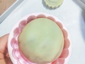 月饼坯要沾上少许面粉，以防沾连，记得抖掉多余的粉，尽可能避免月饼裹的粉太多，饼皮太干，导致开裂。放平往下直接按压至烤盘，可减少挪动，避免变形。