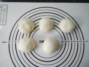 取出来排气，将面团分成10份，揉圆，保鲜膜盖好，静置松弛15分钟。