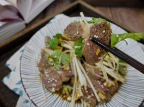 把牛肉切薄片，放上大葱丝、香菜、白芝麻和自制的凉拌汁，拌匀后就可以吃了。