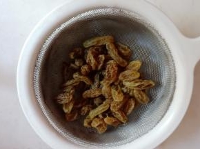 葡萄干先用温水泡软，沥干，用厨房纸吸干水分。