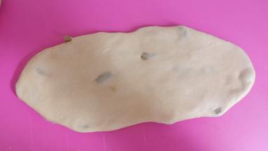 将面团擀成椭圆形。