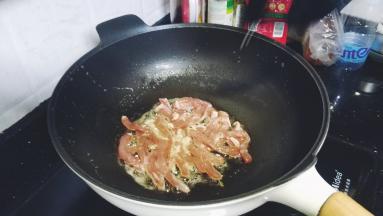 锅里热油，放入蒜蓉爆香再倒入猪扒煸炒