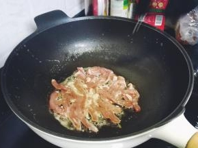 锅里热油，放入蒜蓉爆香再倒入猪扒煸炒