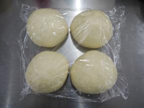 把发酵好的面团取出排气，分割成4份，滚圆后松弛20分钟。